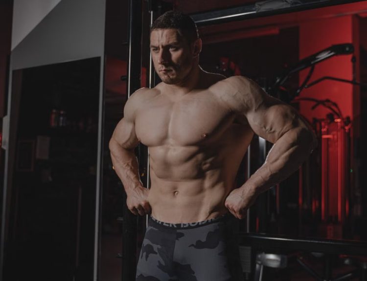 Shirtless bodybuilder flexing muscles under dramatic gym lighting. Fitness and strength.